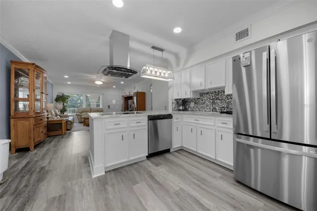a kitchen with a white cabinets and chandelier