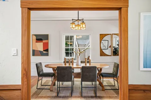 a dining room with furniture a chandelier and wooden floor