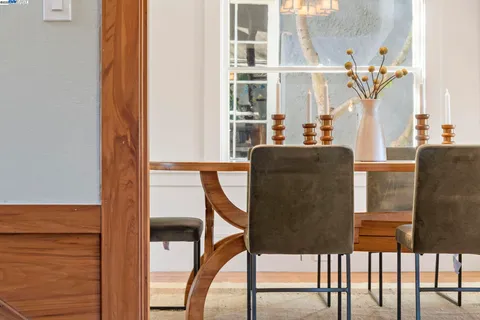 a dining room with furniture a chandelier and wooden floor