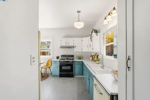 a kitchen with stainless steel appliances granite countertop a sink a stove a refrigerator and cabinets