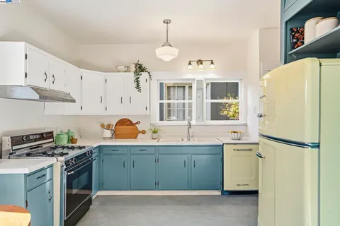 a kitchen with stainless steel appliances granite countertop a refrigerator a stove a sink and a dining table with garden view