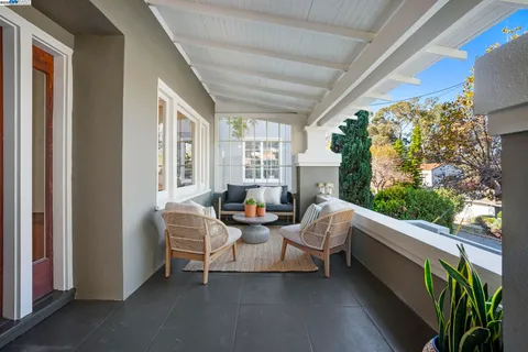a living room with patio furniture and a potted plant