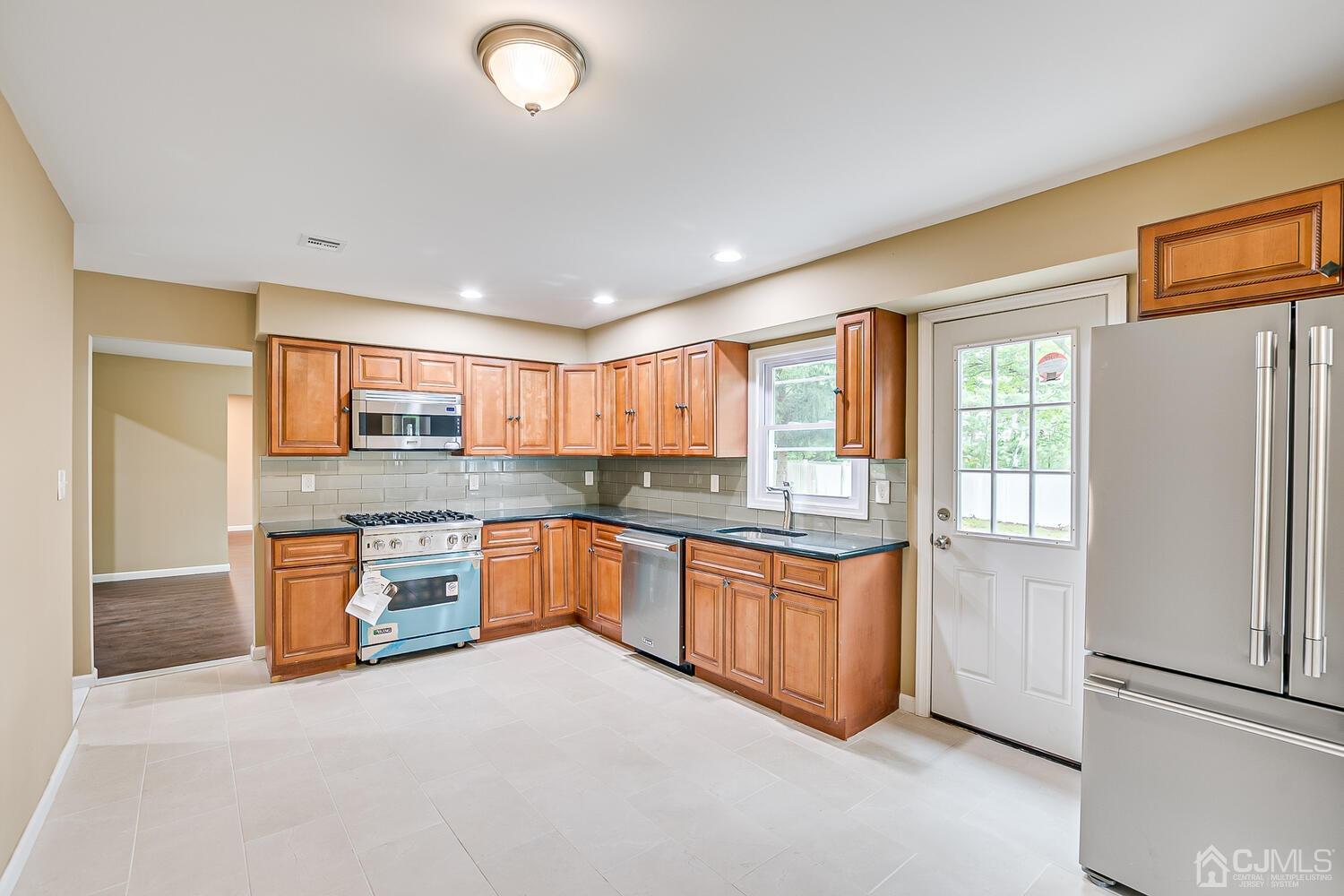 1 Lynnwood Road Edison, NJ 08820 - Photo 18 of 41 a large kitchen with stainless steel appliances granite countertop a refrigerator and a stove top oven