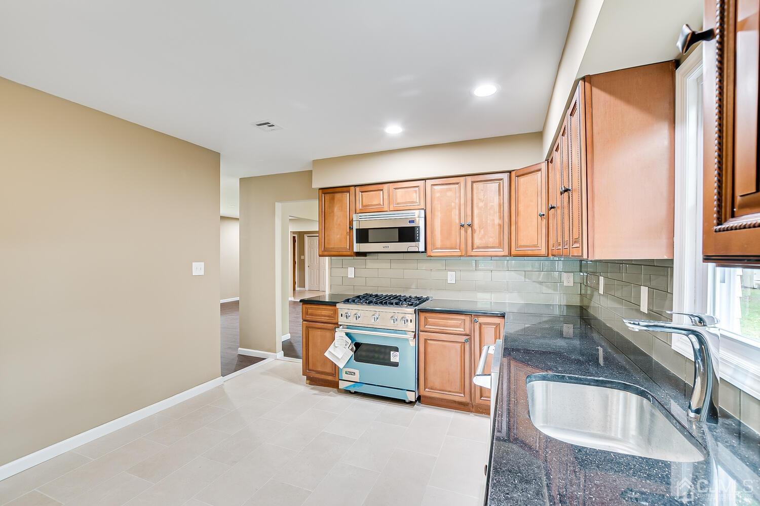 1 Lynnwood Road Edison, NJ 08820 - Photo 21 of 41 a kitchen with stainless steel appliances granite countertop a sink a stove and a refrigerator