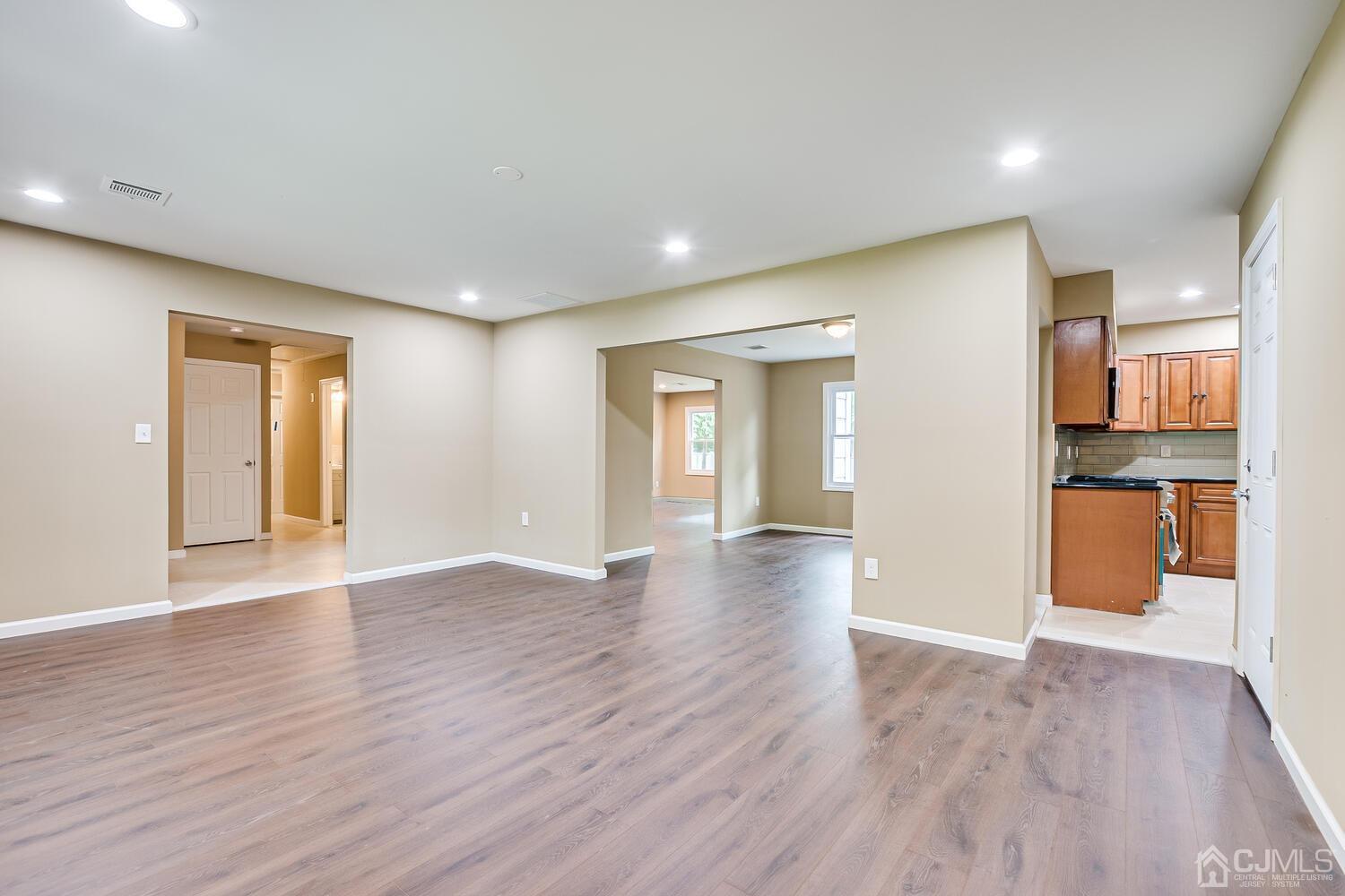 1 Lynnwood Road Edison, NJ 08820 - Photo 10 of 41 a view of an empty room with wooden floor and a kitchen