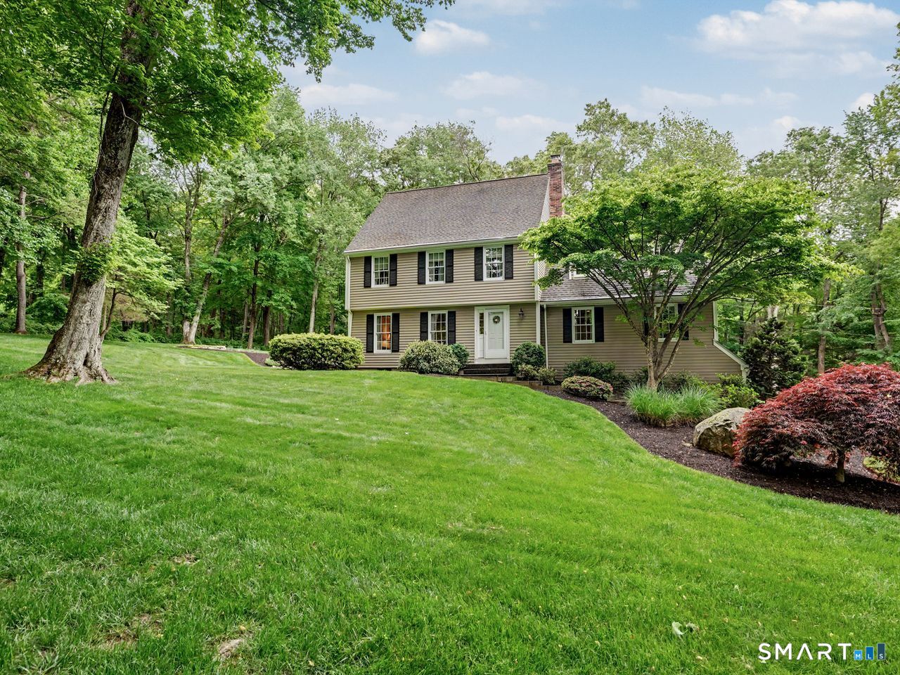 86 Fire Hill Road Redding, CT 06896 - Photo 2 of 36 a front view of a house with a garden