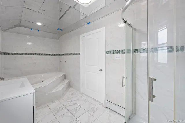 a bathroom with a tub shower vanity and a sink