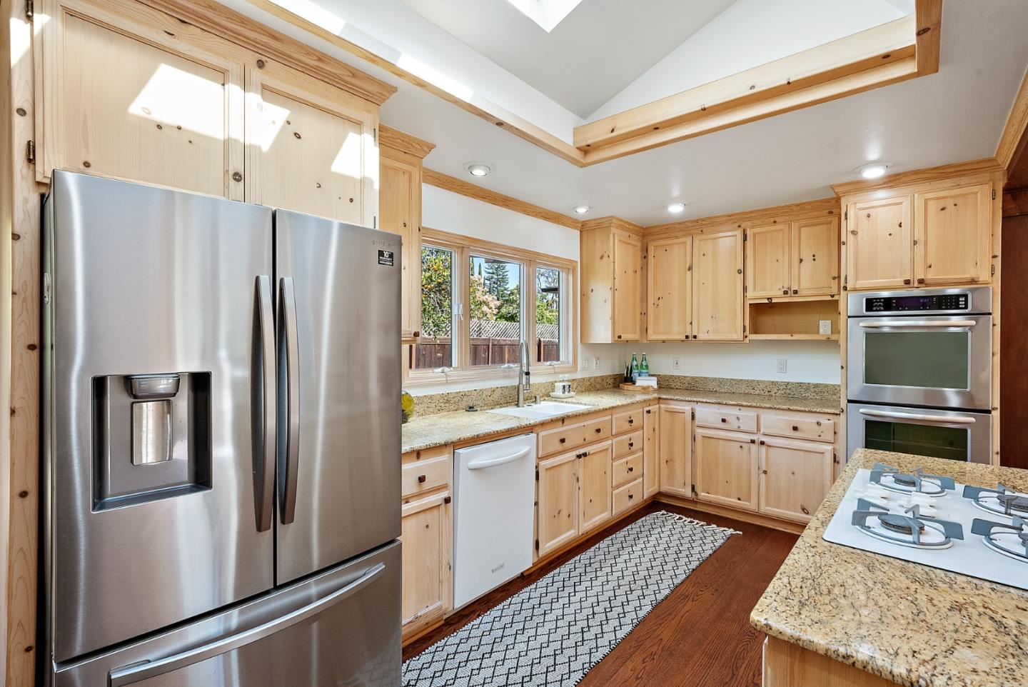425 Covington Road Los Altos, CA 94024 - Photo 24 of 65 a kitchen with stainless steel appliances granite countertop a refrigerator a sink dishwasher a stove and white countertops with wooden floor