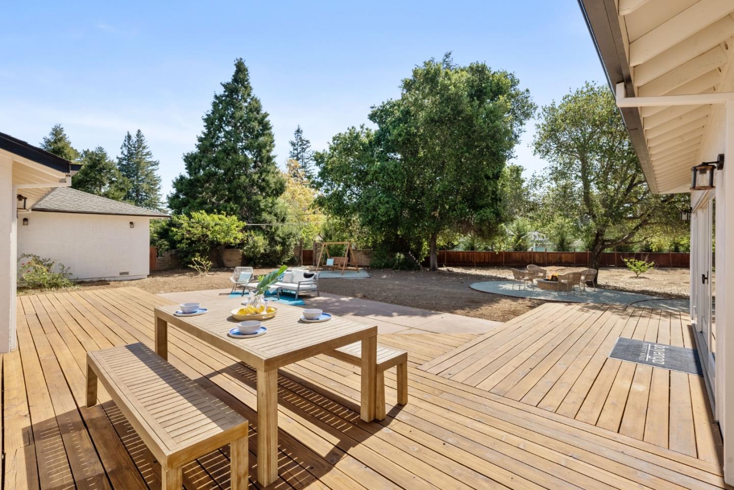 425 Covington Road Los Altos, CA 94024 - Photo 57 of 65 a view of a patio with dining table and chairs with wooden floor and fence
