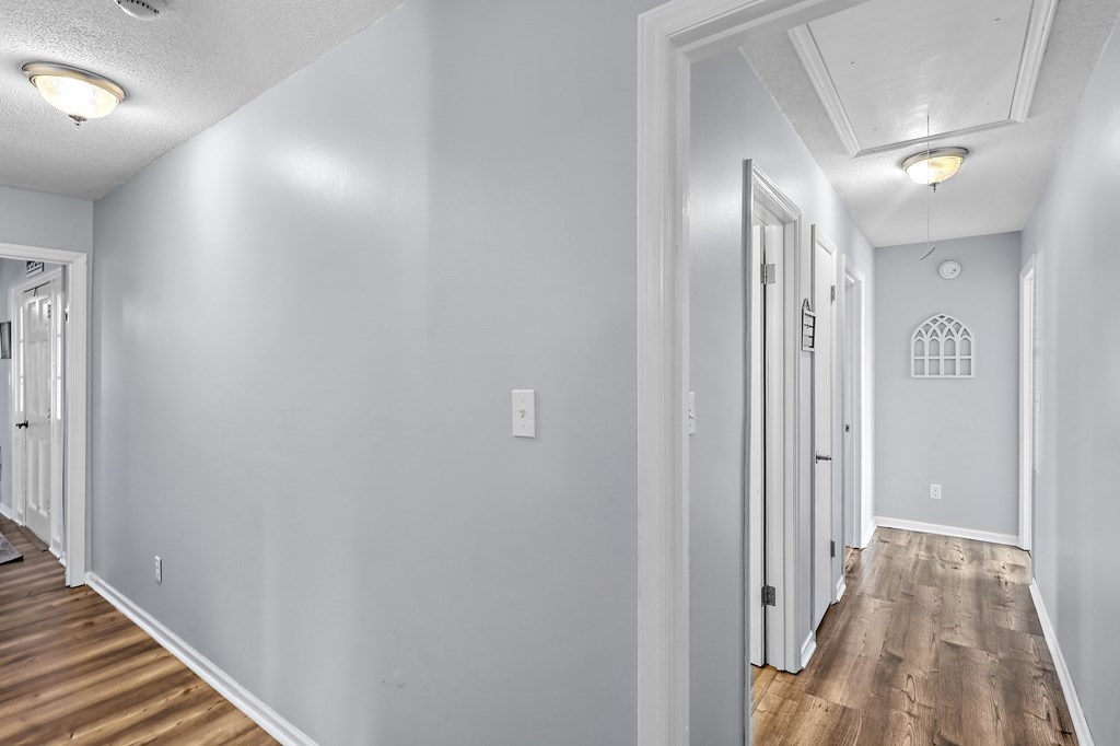 202 Wilton Road Abbeville, SC 29620 - Photo 12 of 35 This interior hallway offers a warm welcome with durable wood flooring and functional lighting.