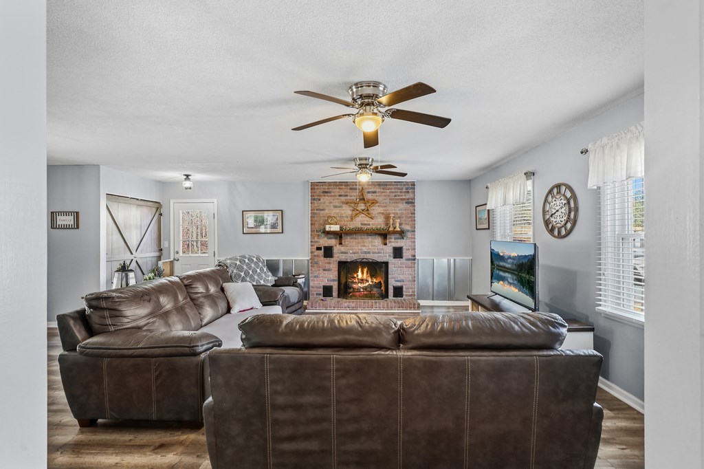 202 Wilton Road Abbeville, SC 29620 - Photo 15 of 35 This inviting family room features a warm brick fireplace, perfect for cozy gatherings.