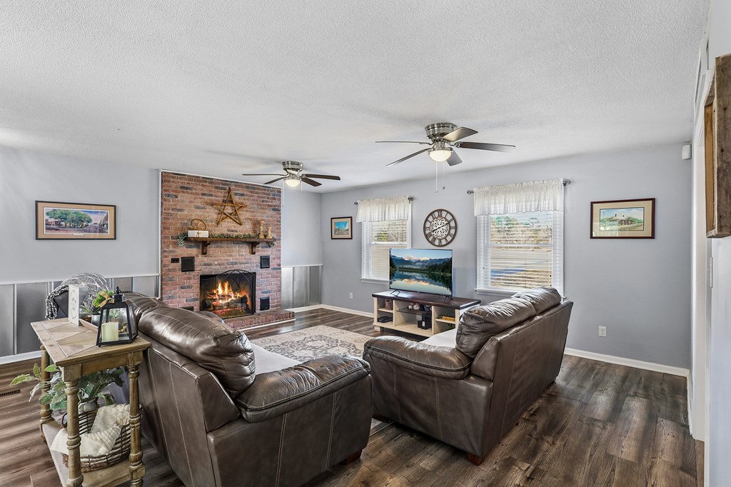 202 Wilton Road Abbeville, SC 29620 - Photo 16 of 35 This inviting family room features a classic brick fireplace and durable wood-look flooring.