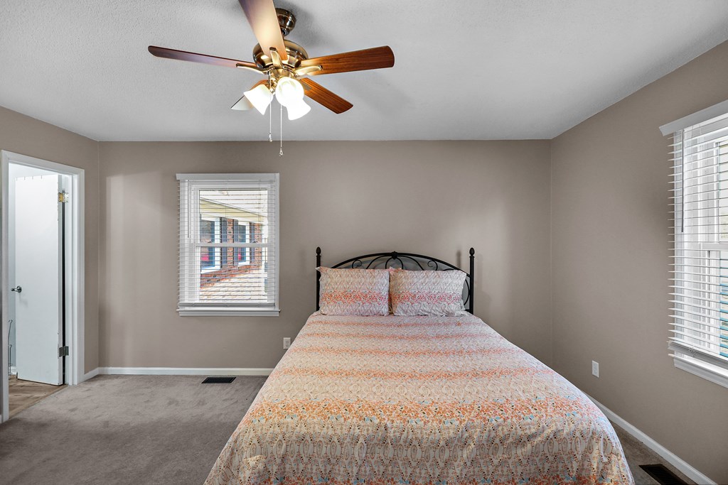 202 Wilton Road Abbeville, SC 29620 - Photo 25 of 35 This cozy bedroom features plush carpeting and a classic ceiling fan, offering a comfortable retreat.