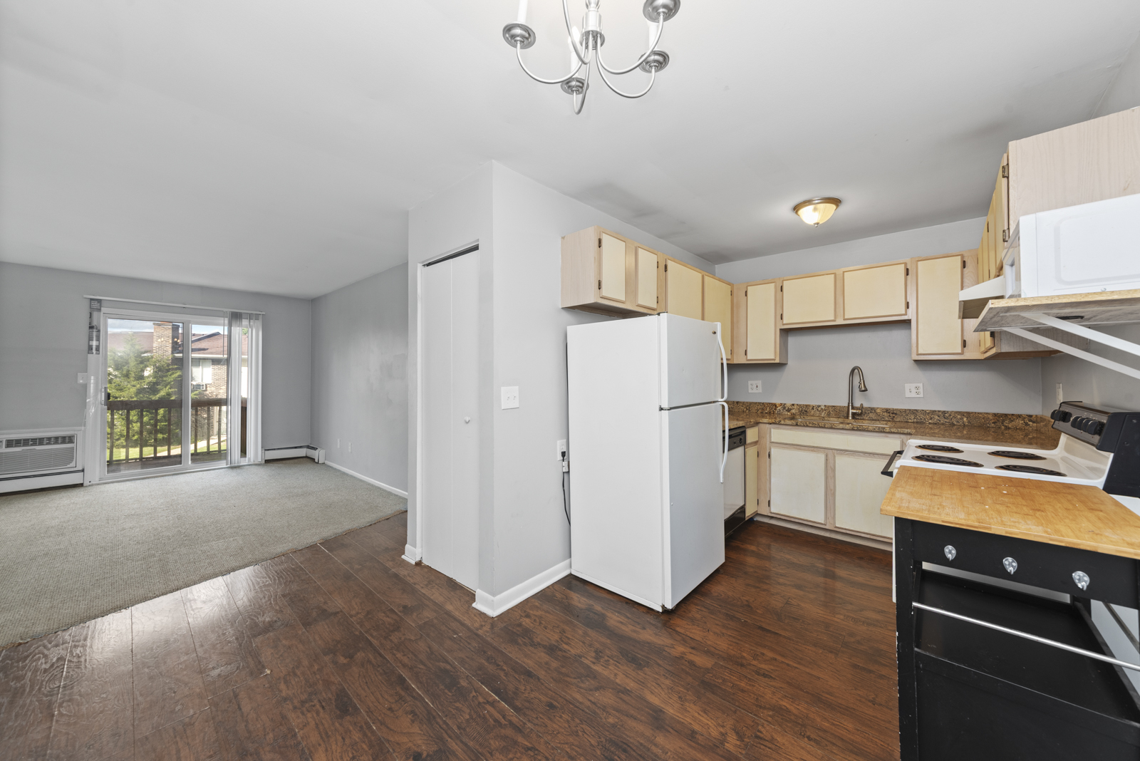 2400 Light Road, Unit 212 Oswego, IL 60543 - Photo 7 of 14 a kitchen with stainless steel appliances granite countertop a refrigerator a sink dishwasher a stove and white countertops with wooden floor