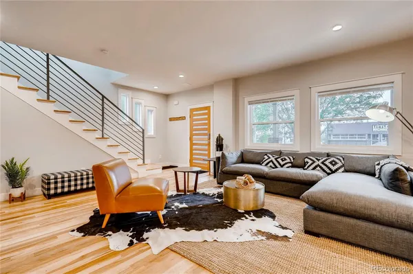 a living room with furniture and a wooden floor