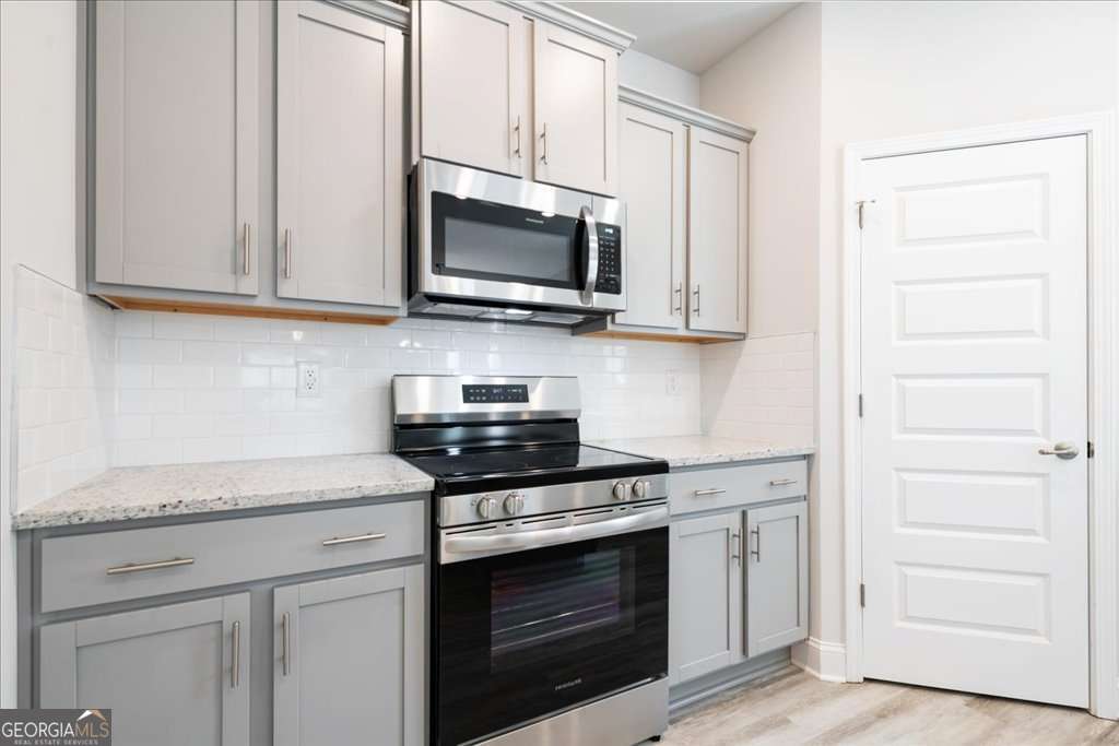 219 Carsons Walk Macon, GA 31206 - Photo 19 of 57 a kitchen with stainless steel appliances white cabinets and a stove top oven