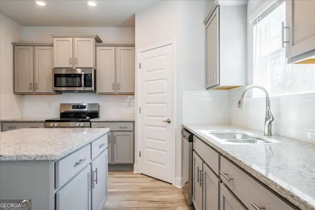 a kitchen with granite countertop a sink and cabinets