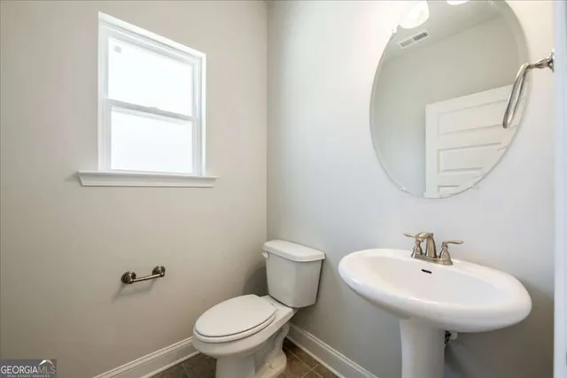 a bathroom with a toilet a sink and a window