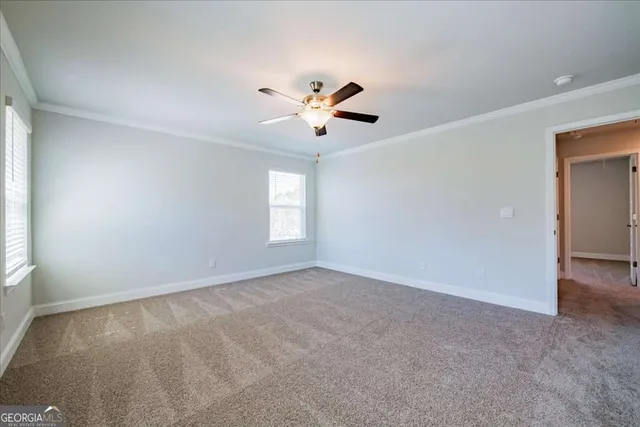 an empty room with windows and chandelier fan