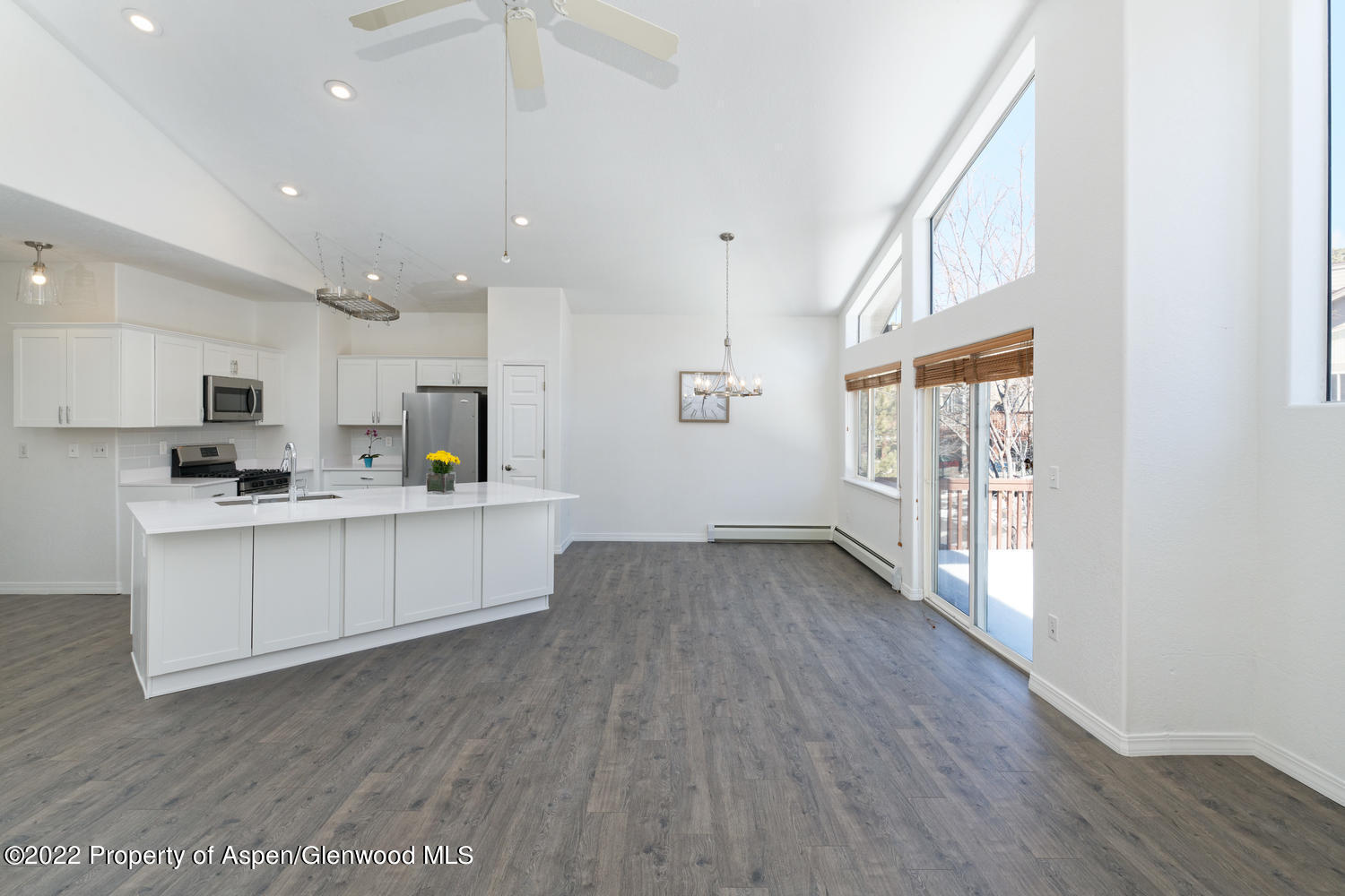 a kitchen with a refrigerator and white cabinets
