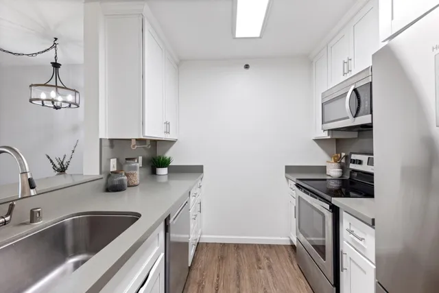 a kitchen with stainless steel appliances a sink stove and cabinets