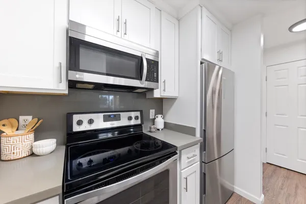 a kitchen with stainless steel appliances a stove microwave and refrigerator