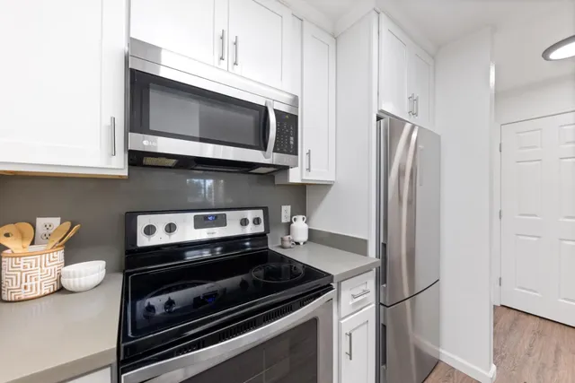 a kitchen with stainless steel appliances a stove microwave and refrigerator