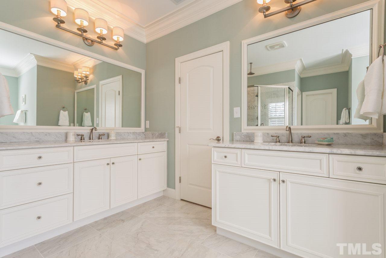 5012 Pomfret Point Raleigh, NC 27612 - Photo 12 of 25 The 2 bath vanities are generous in size and feature marble counter tops. Additional features include framed mirrors, stylish light fixtures, and brushed nickel bath fixtures.