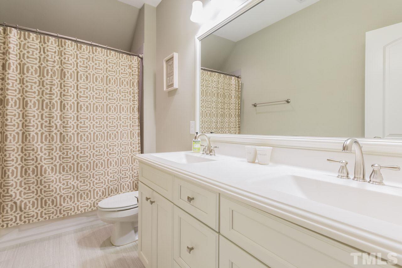 5012 Pomfret Point Raleigh, NC 27612 - Photo 16 of 25 This bathroom has a long vanity with double rectangular sinks, a framed mirror, and a tub/shower combination with tile surround.