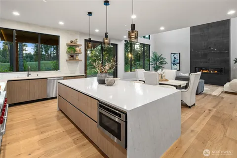 a large kitchen with kitchen island a large window in it