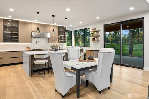 a dining room with furniture a large window and wooden floor