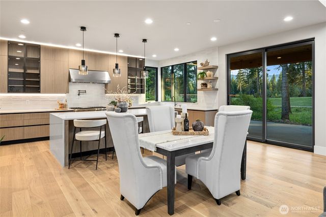 a dining room with furniture a large window and wooden floor