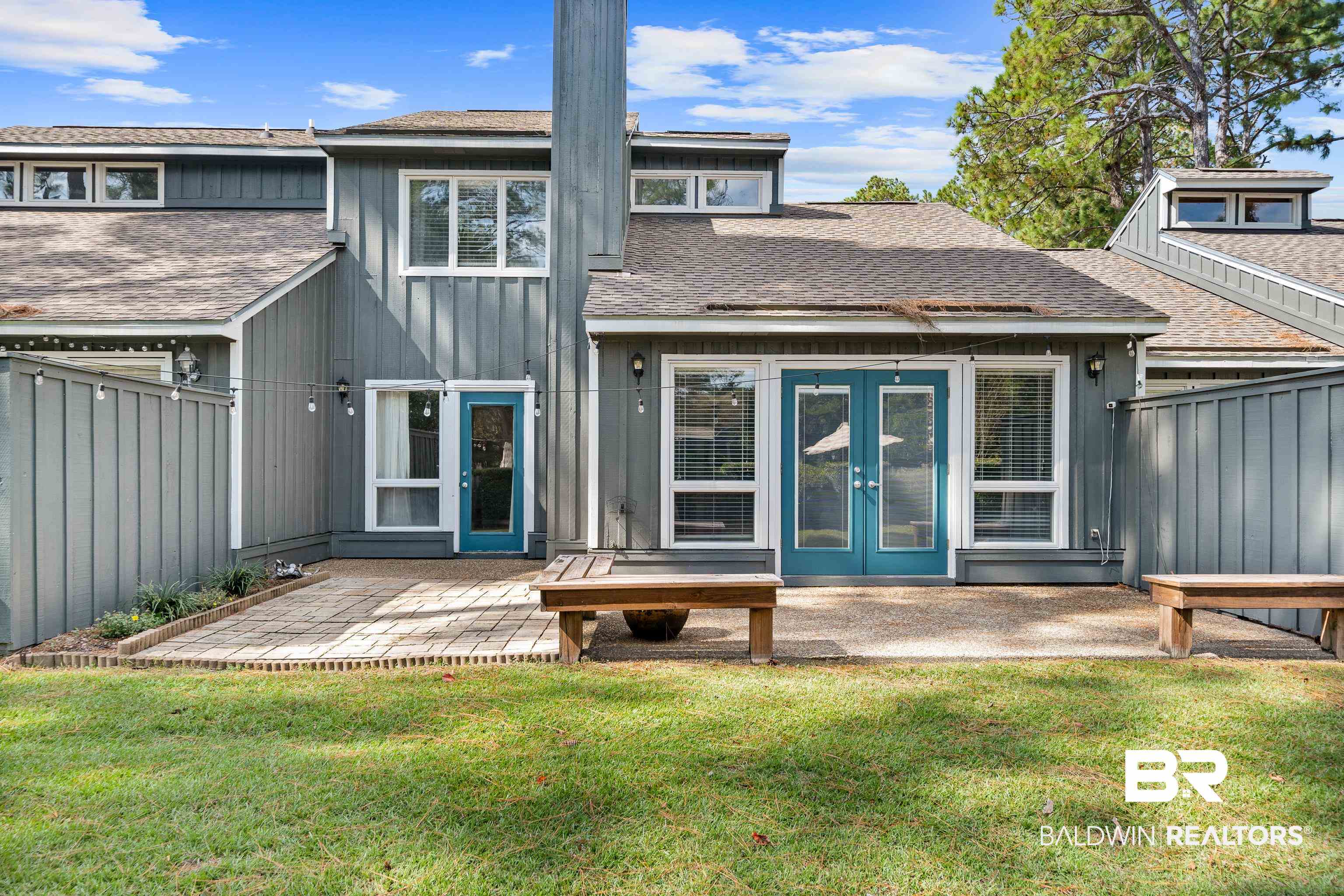 1701 Regency Road, Unit 111 Gulf Shores, AL 36542 - Photo 23 of 29 Back of property featuring a yard, a patio, and french doors