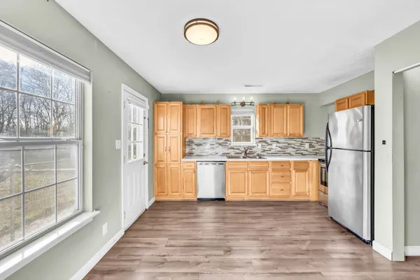 a kitchen with a refrigerator and white cabinets