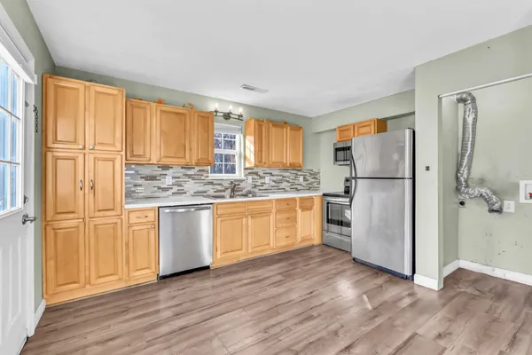 a kitchen with stainless steel appliances a refrigerator and wooden cabinets