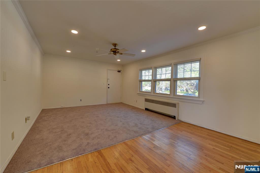 255 Bogert Road, Unit 2A River Edge, NJ 07661 - Photo 5 of 25 an empty room with wooden floor and windows
