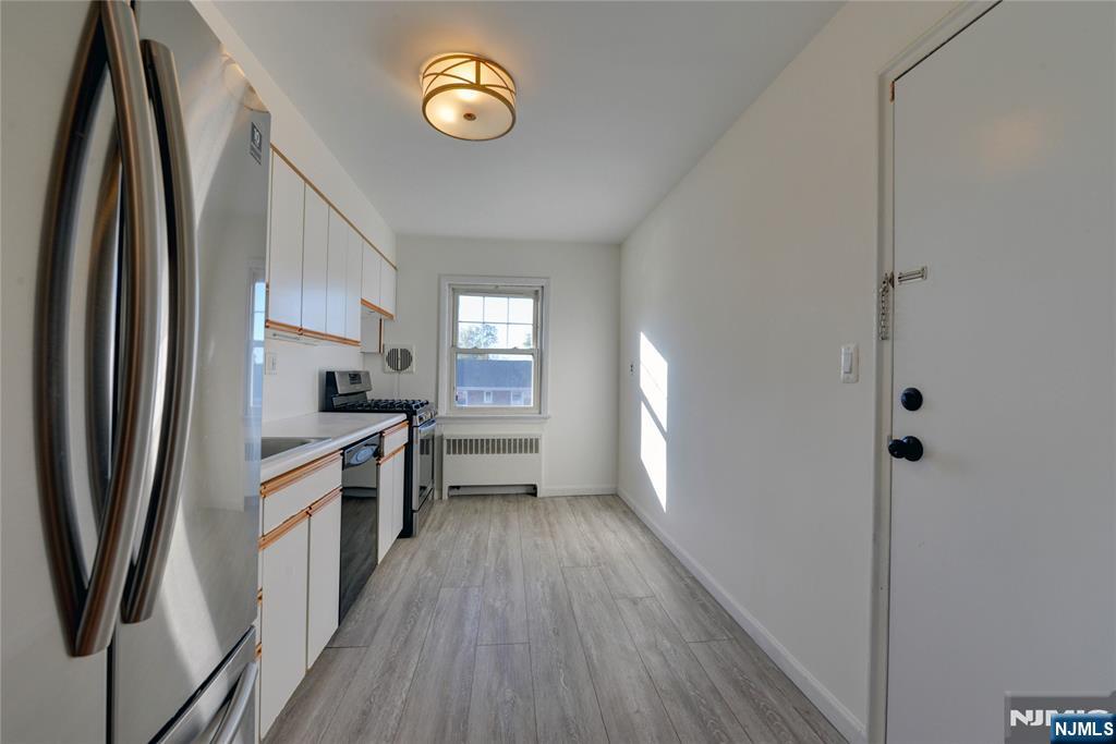 255 Bogert Road, Unit 2A River Edge, NJ 07661 - Photo 6 of 25 a kitchen with stainless steel appliances a refrigerator sink and stove