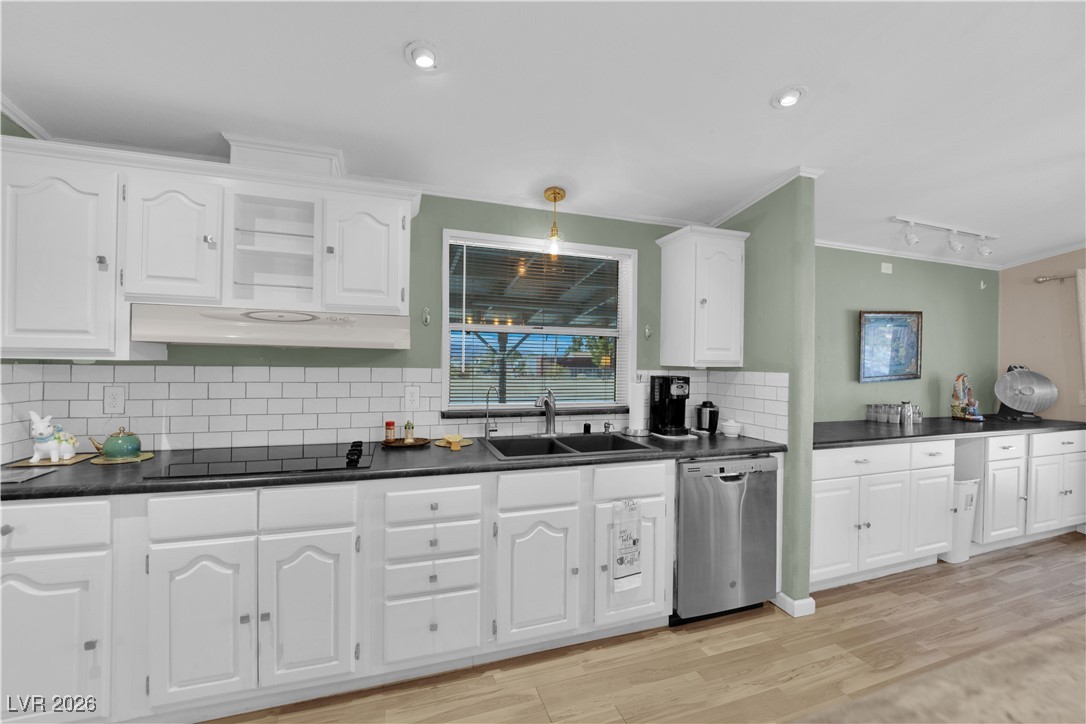5550 Vicki Ann Road Pahrump, NV 89048 - Photo 29 of 44 Kitchen with crown molding, white cabinets, stainless steel dishwasher, dark countertops, and decorative backsplash
