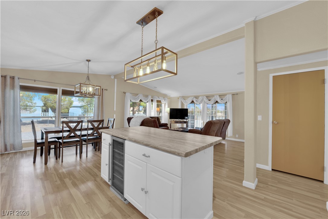 5550 Vicki Ann Road Pahrump, NV 89048 - Photo 43 of 44 Kitchen featuring open floor plan, pendant lighting, white cabinets, light wood-type flooring, and lofted ceiling