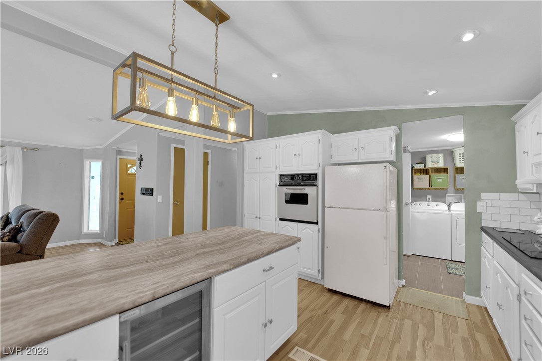 5550 Vicki Ann Road Pahrump, NV 89048 - Photo 44 of 44 Kitchen featuring white cabinetry, freestanding refrigerator, open floor plan, beverage cooler, and light wood-style flooring