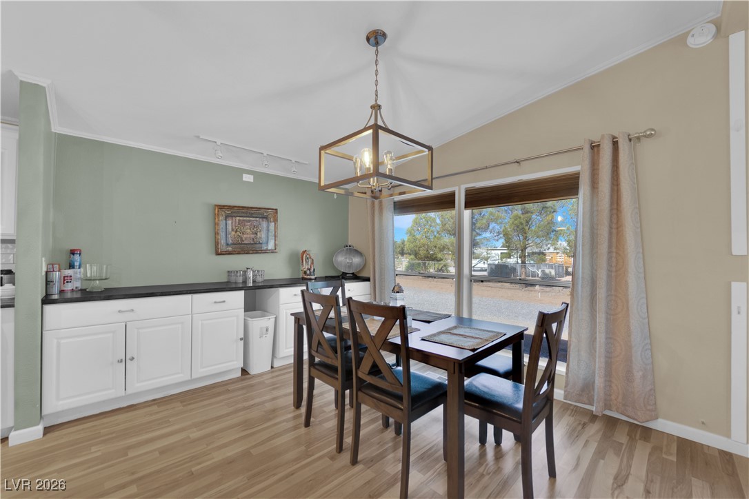 5550 Vicki Ann Road Pahrump, NV 89048 - Photo 33 of 44 Dining area with crown molding, light wood finished floors, rail lighting, and a chandelier