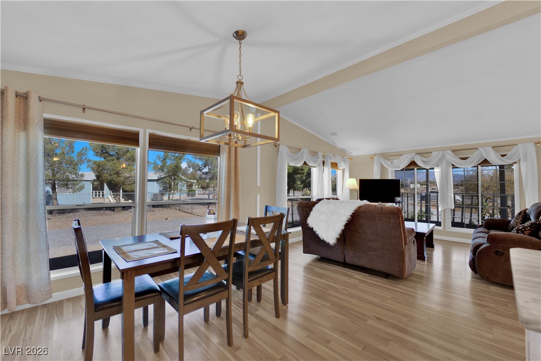 5550 Vicki Ann Road Pahrump, NV 89048 - Photo 34 of 44 Dining space featuring light wood-style floors, vaulted ceiling, a chandelier, and ornamental molding
