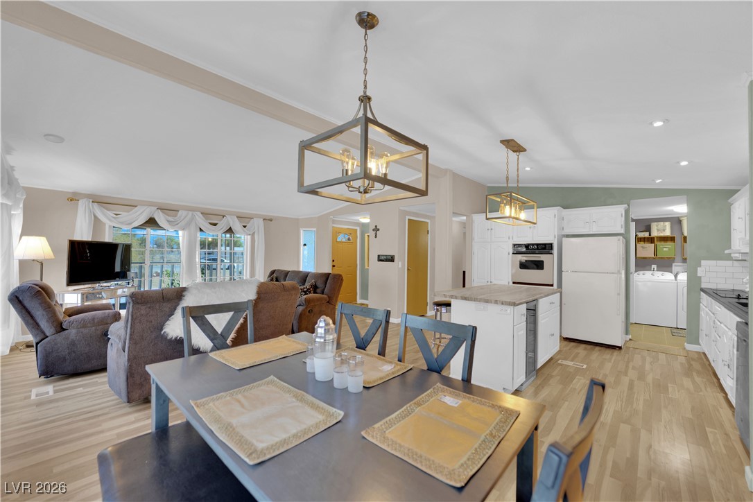 5550 Vicki Ann Road Pahrump, NV 89048 - Photo 35 of 44 Dining space with light wood-style floors, lofted ceiling, washing machine and dryer, a chandelier, and recessed lighting