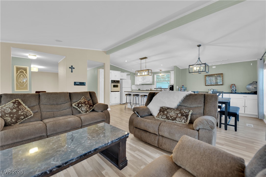 5550 Vicki Ann Road Pahrump, NV 89048 - Photo 37 of 44 Living room featuring ornamental molding, light wood-type flooring, lofted ceiling, and recessed lighting