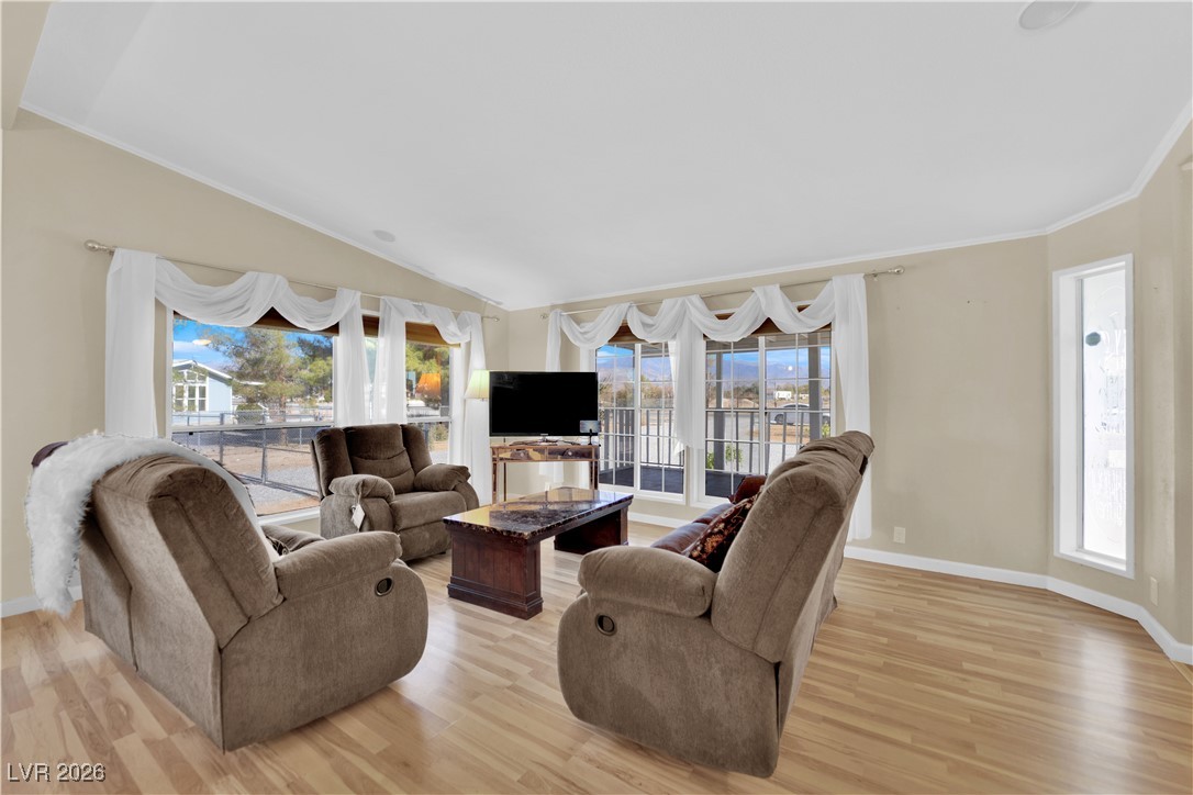 5550 Vicki Ann Road Pahrump, NV 89048 - Photo 38 of 44 Living room with healthy amount of natural light, light wood finished floors, crown molding, and lofted ceiling
