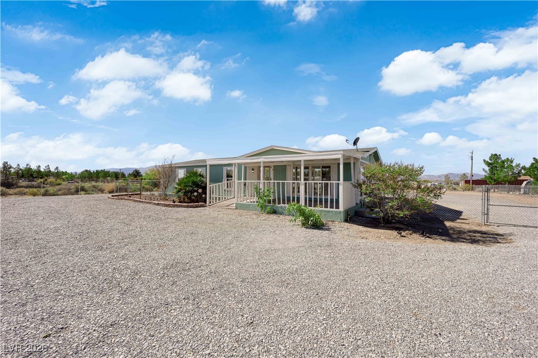 5550 Vicki Ann Road Pahrump, NV 89048 - Photo 42 of 44 Back of house featuring a porch and a gate