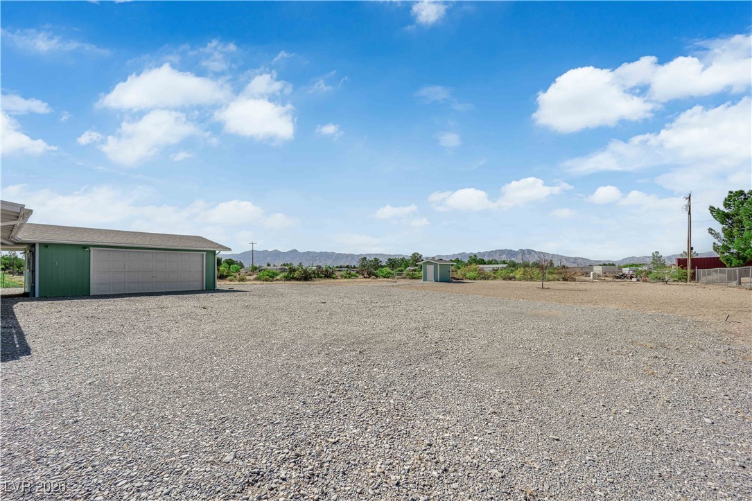 5550 Vicki Ann Road Pahrump, NV 89048 - Photo 9 of 44 View of yard featuring a mountain view, an outbuilding, and a garage