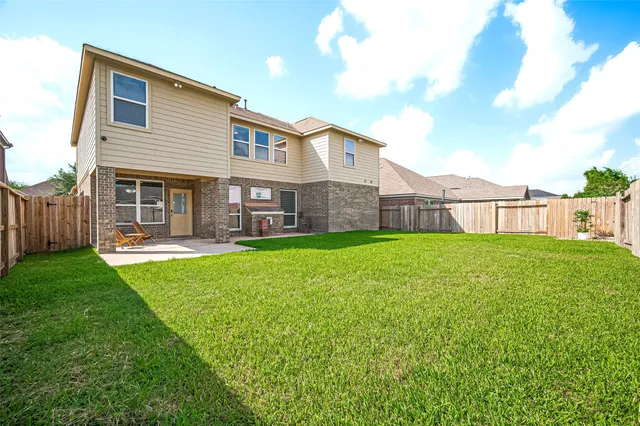 a view of a house with a yard and a patio