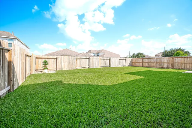 a view of a house with a big yard and large trees