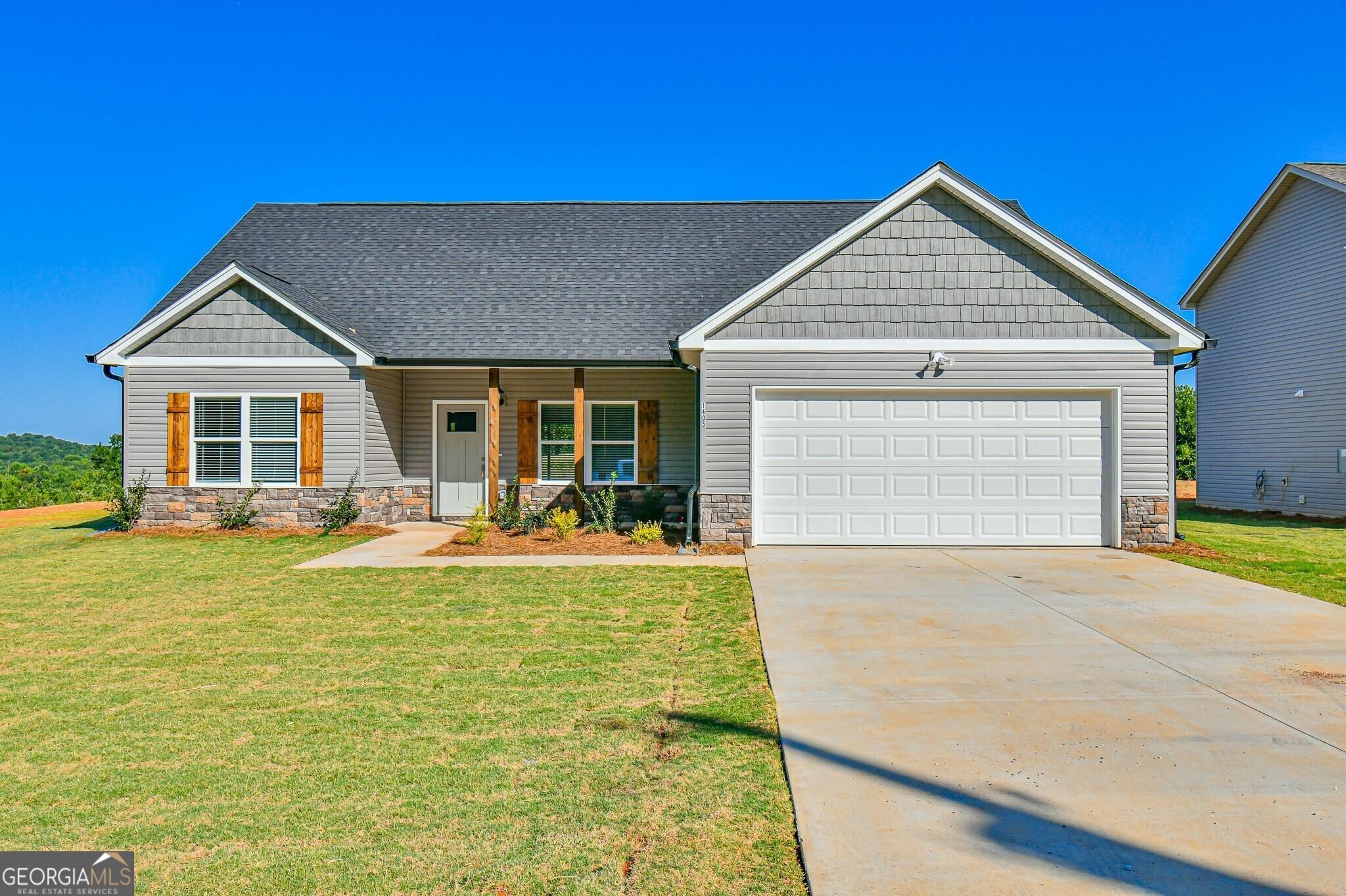 a front view of a house with a yard outdoor seating and garage